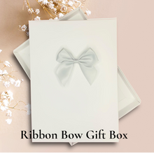 Load image into Gallery viewer, a white gift box with a bow on it, placed on a pink background.