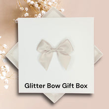 Load image into Gallery viewer, A white gift box with a bow on top, placed on a pink background.