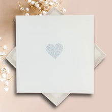 Load image into Gallery viewer, a white square card with a heart symbol in the center, placed on a pink background.