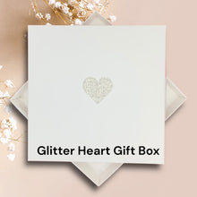 Load image into Gallery viewer, A white gift box with a heart-shaped design on it, placed on a pink background.
