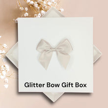 Load image into Gallery viewer, A white gift box with a bow on top, placed on a pink background.
